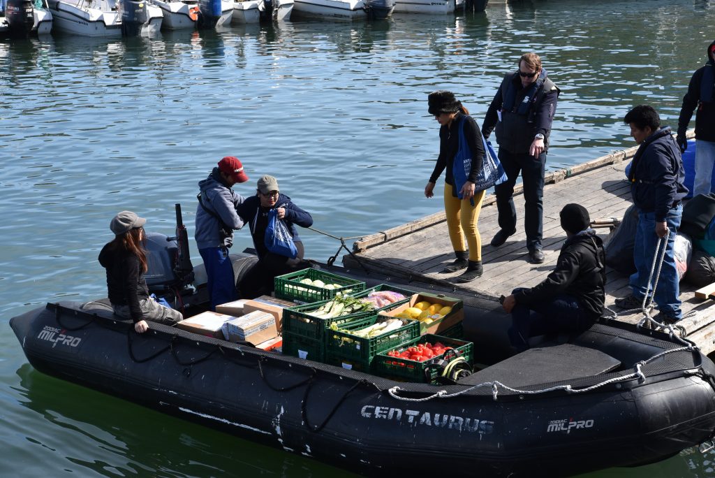 En même temps que des passagers, des caisses de fruits et de légumes retournent sur le bateau au port d'Ilulissat. Photo : Véronique Leduc.