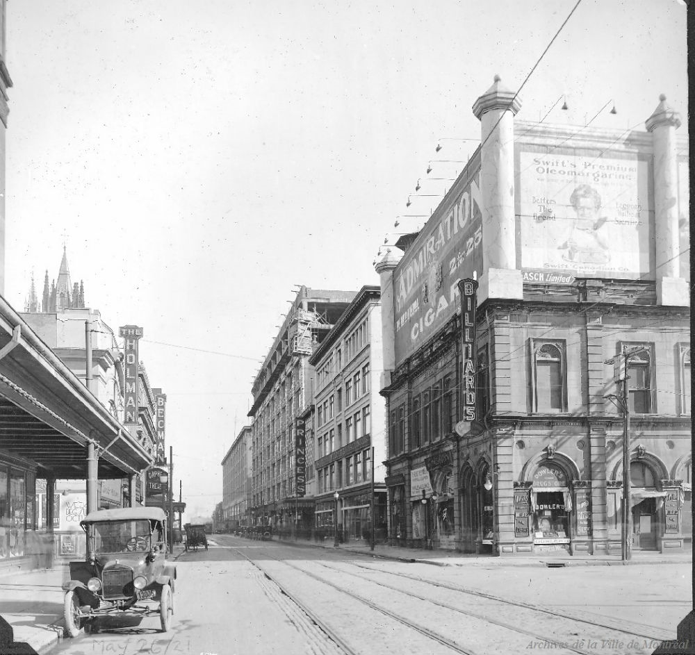 Cinéma The Holman en 1921. Photographie de la rue Sainte-Catherine, à l'angle du square Phillips. À gauche, on y aperçoit le cinéma The Holman et le théâtre Orpheum. Photo : Archives de la Ville de Montréal